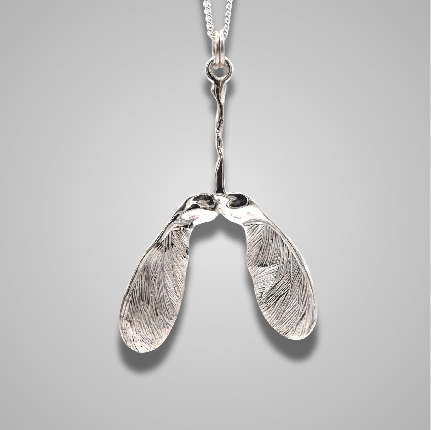 Large sycamore seed pendant made from silver. On a silver chain, a statement piece of jewellery which is sparkly and elegant