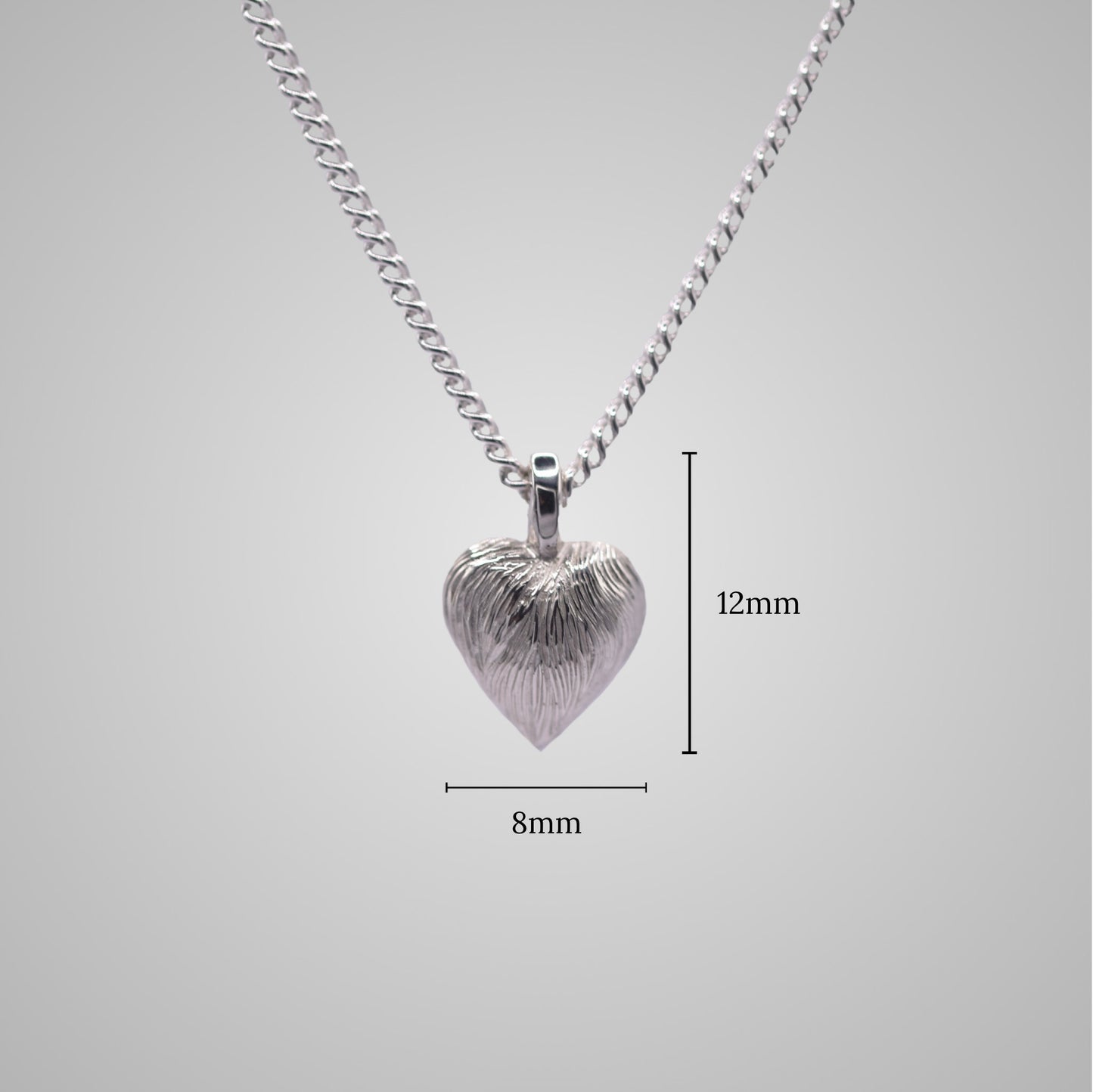 Silver heart pendant on silver chain with shiny engraved flowing lines. Added dimensions of 8mm x 12mm