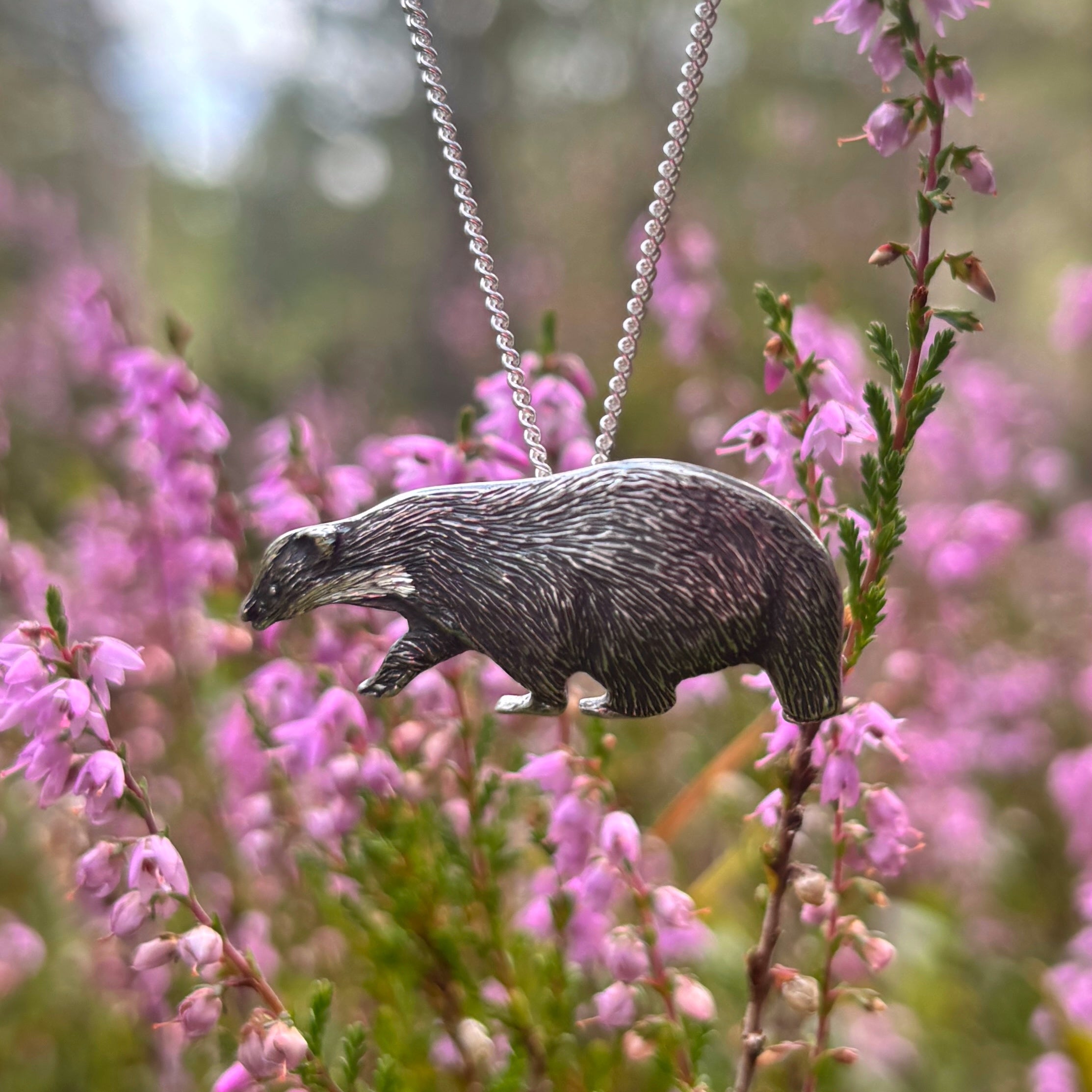 badger pendant against a bokeh heather background