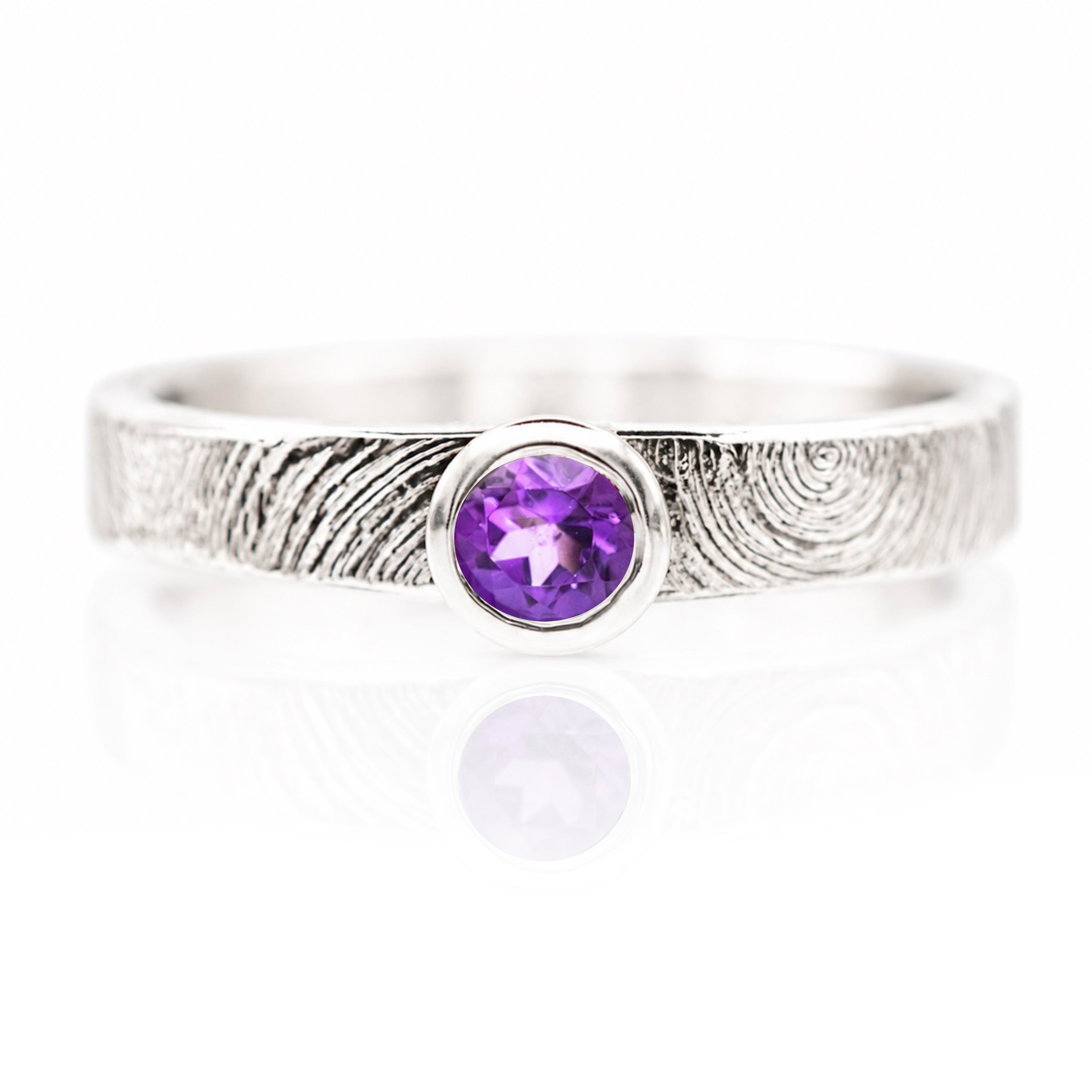 Silver ring with a purple gemstone on a white background