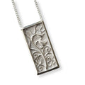 Silver pendant with intricate design of art nouveau bluebells on a white background