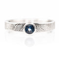 Silver ring with a blue gemstone on a white background