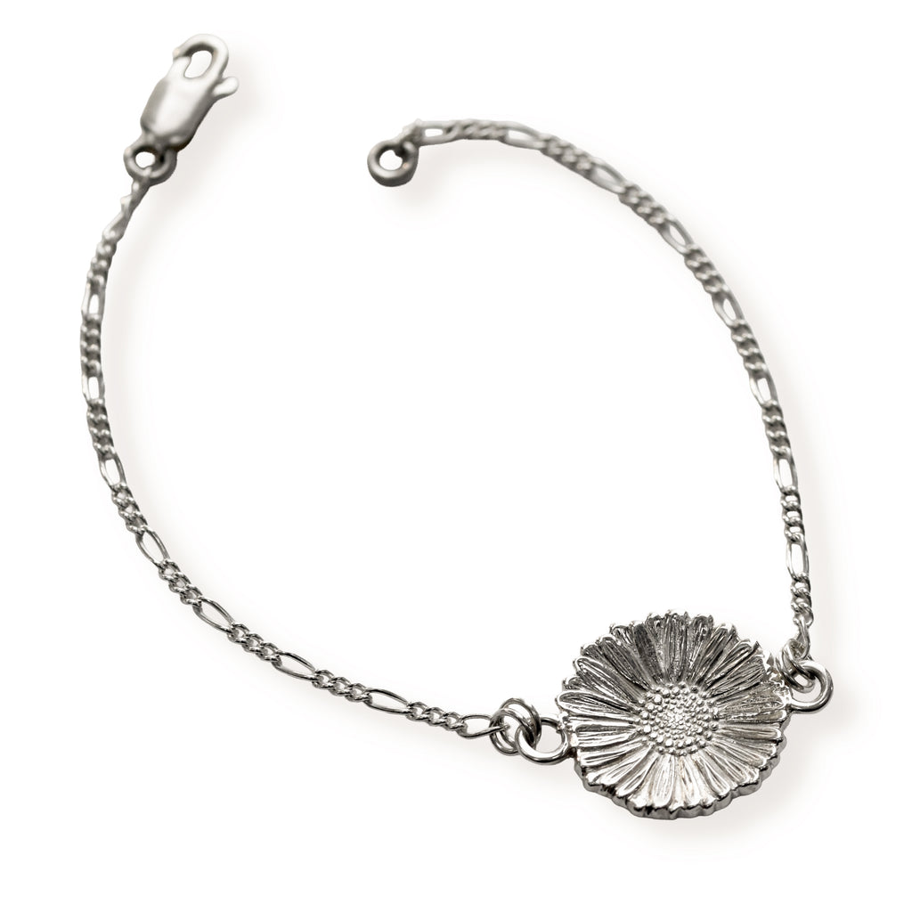 Silver bracelet with a single daisy on a white background