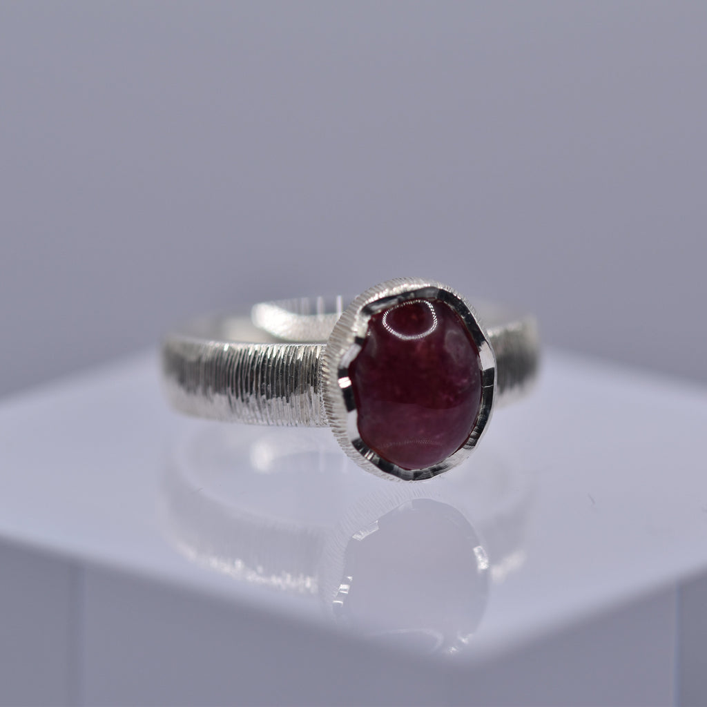 Silver ring with a wavy setting with a pink tourmaline stone in the centre