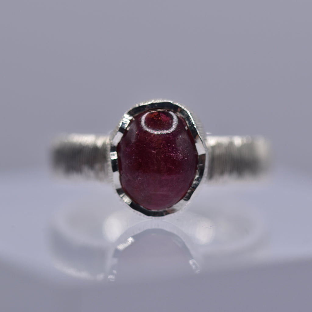 Silver ring with a wavy setting with a pink tourmaline stone in the centre