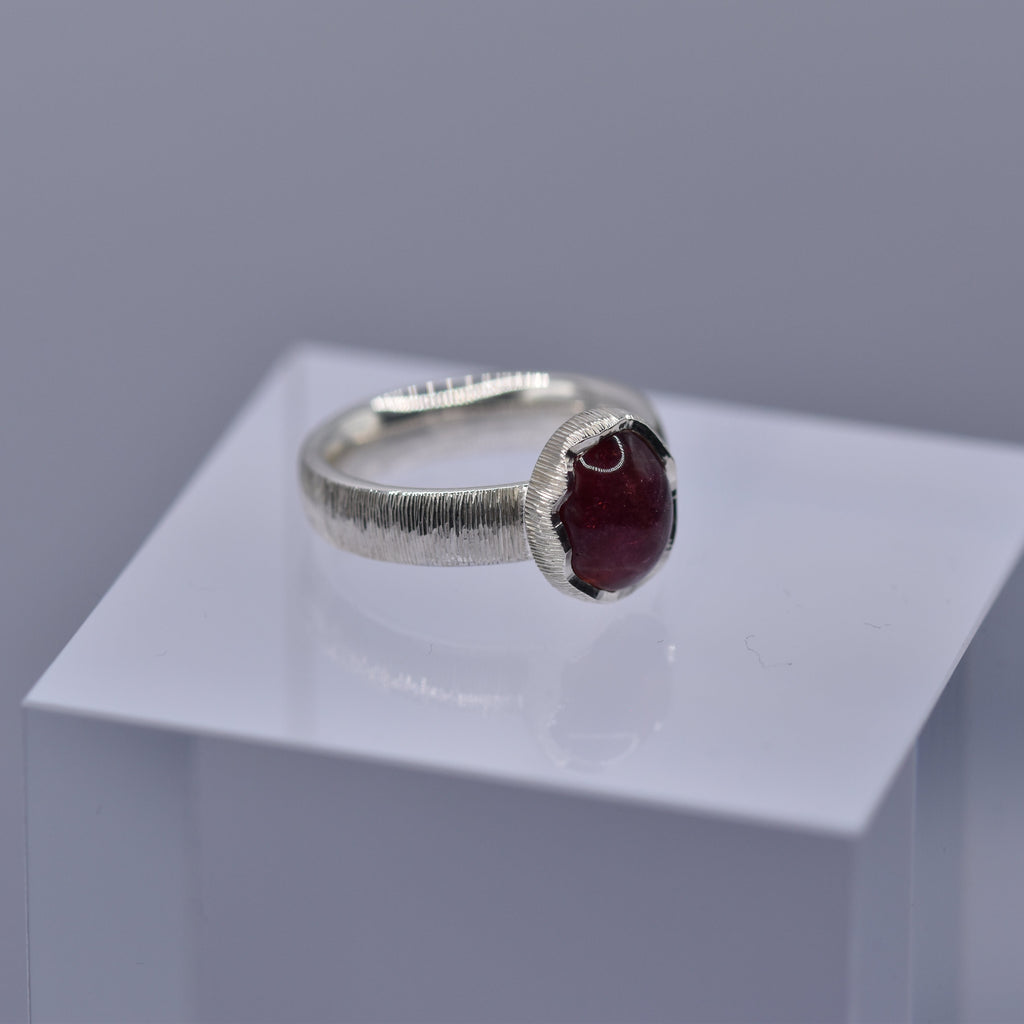 Silver ring with a wavy setting with a pink tourmaline stone in the centre