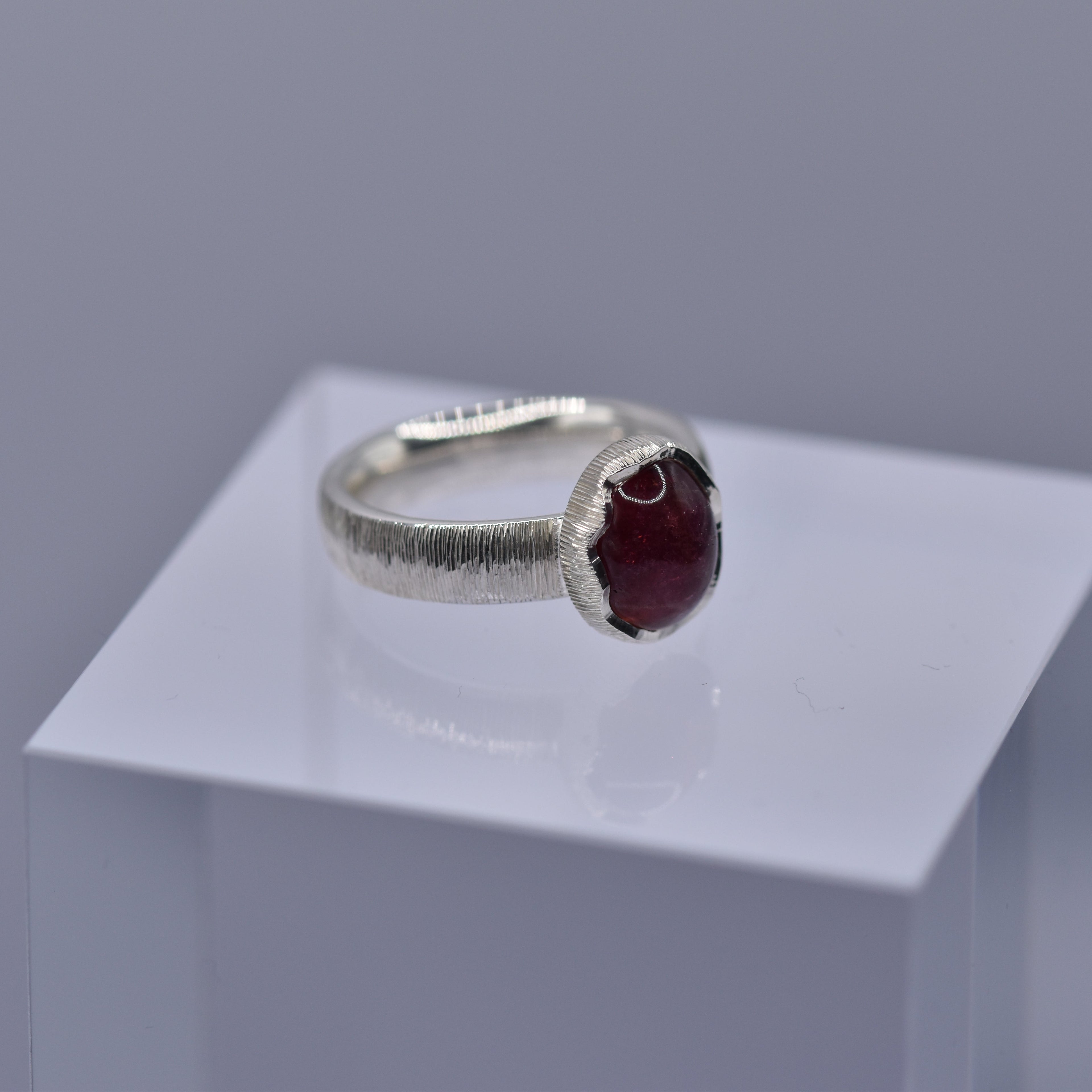 Silver ring with a wavy setting with a pink tourmaline stone in the centre
