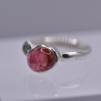 Silver ring with a pink stone on a gray background