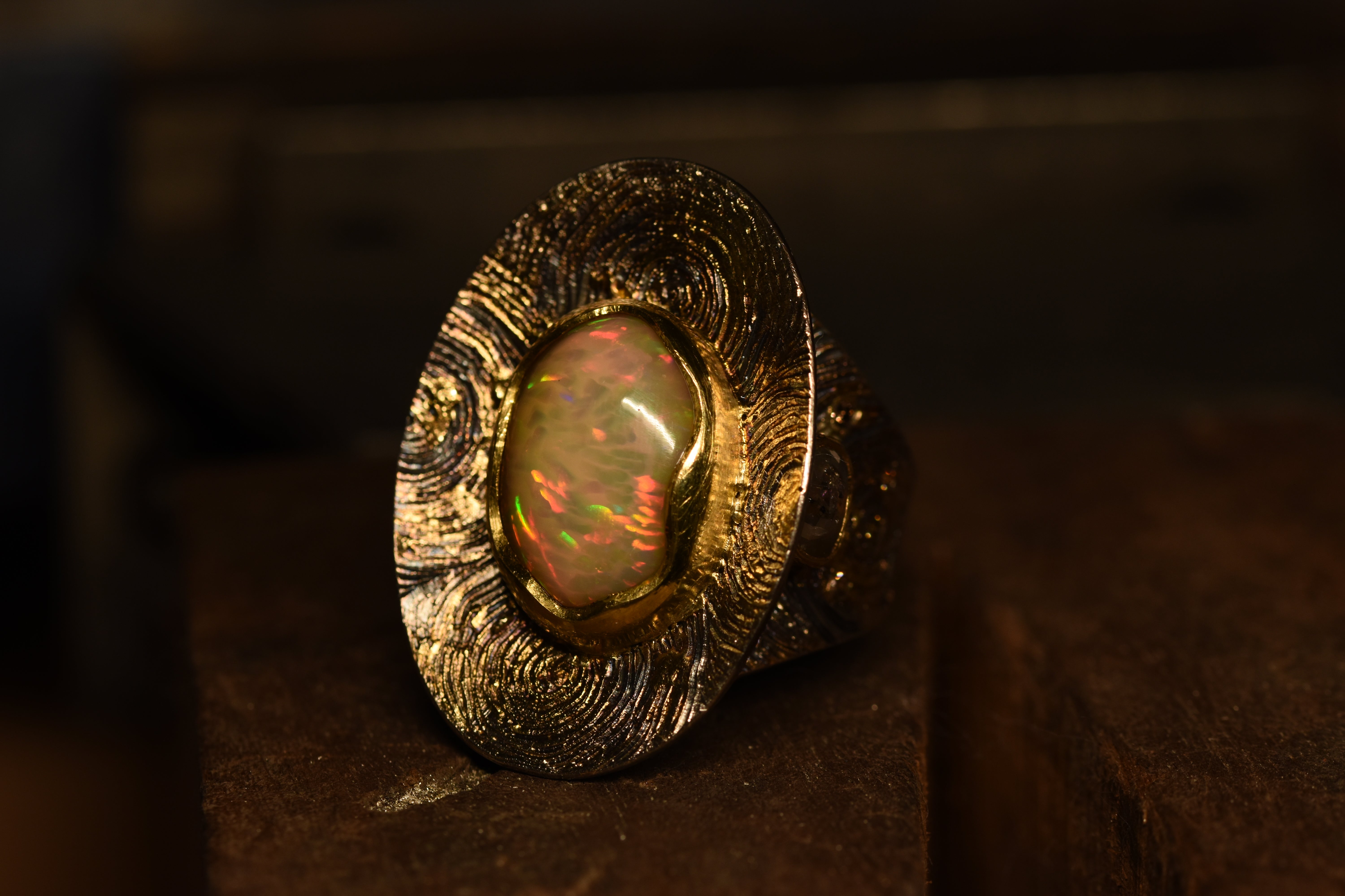 Gold and silver ring with hand engraved pattern with a large central opal set in gold