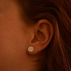 Close-up of an ear wearing a silver geometric earring
