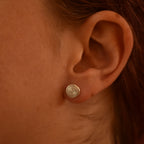 Close-up of an ear wearing a silver spiral earring.