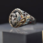 Decorative ring with intricate design on a reflective surface