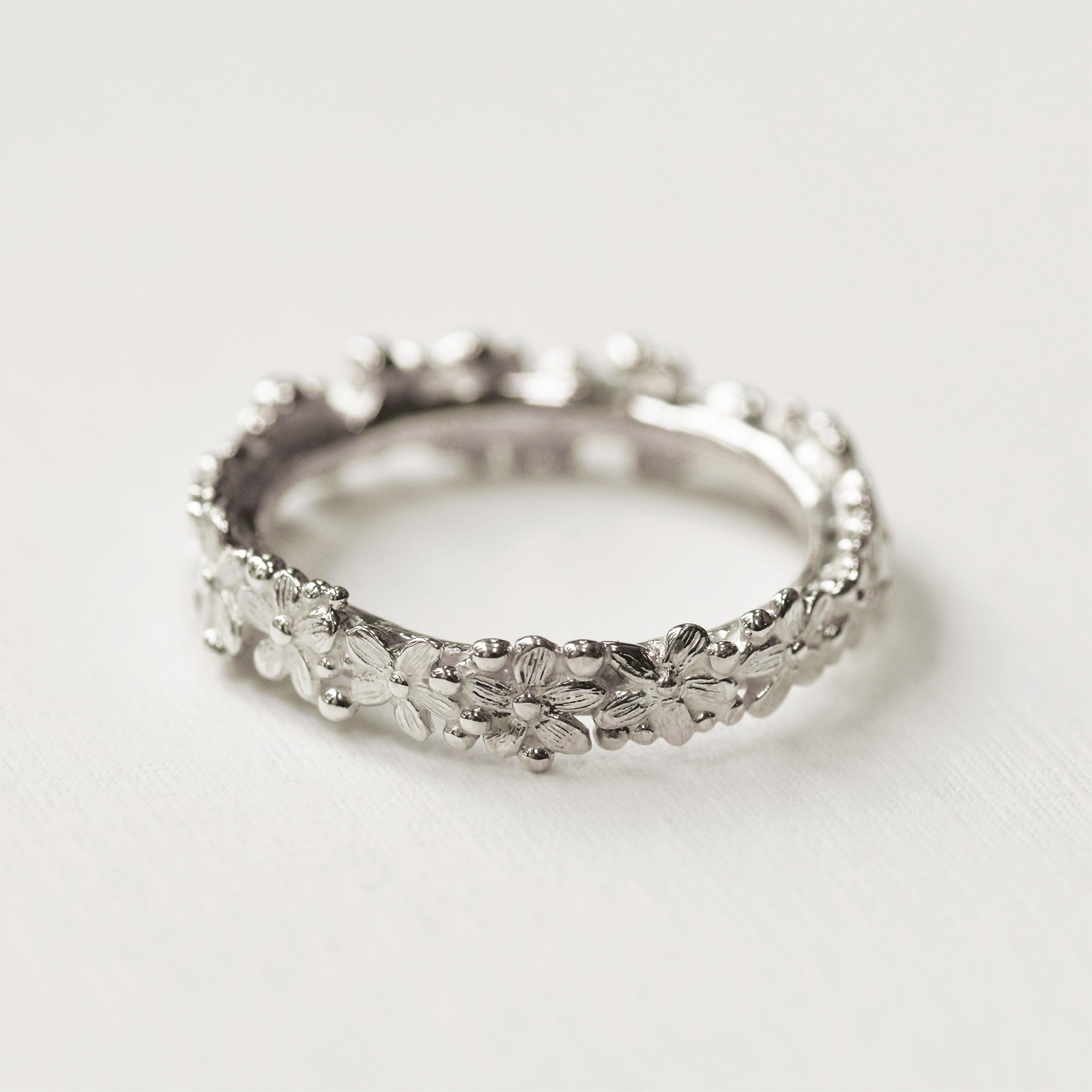 silver ring with flowers all the way around 
