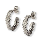 Pair of silver hoop earrings with tiny flowers all the way around on a white background
