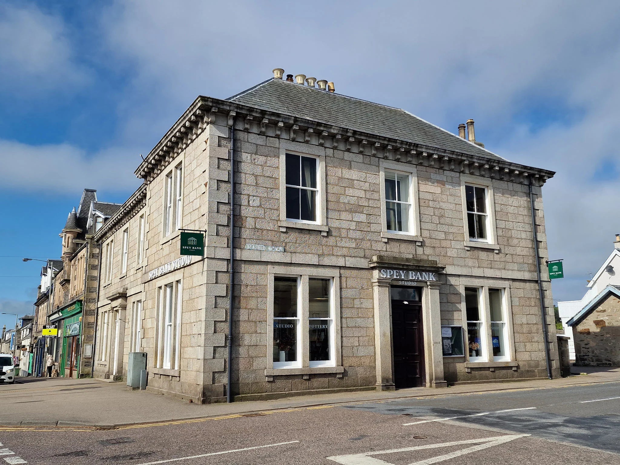 Grey stone building with 'speybank studios' sign on a street corner