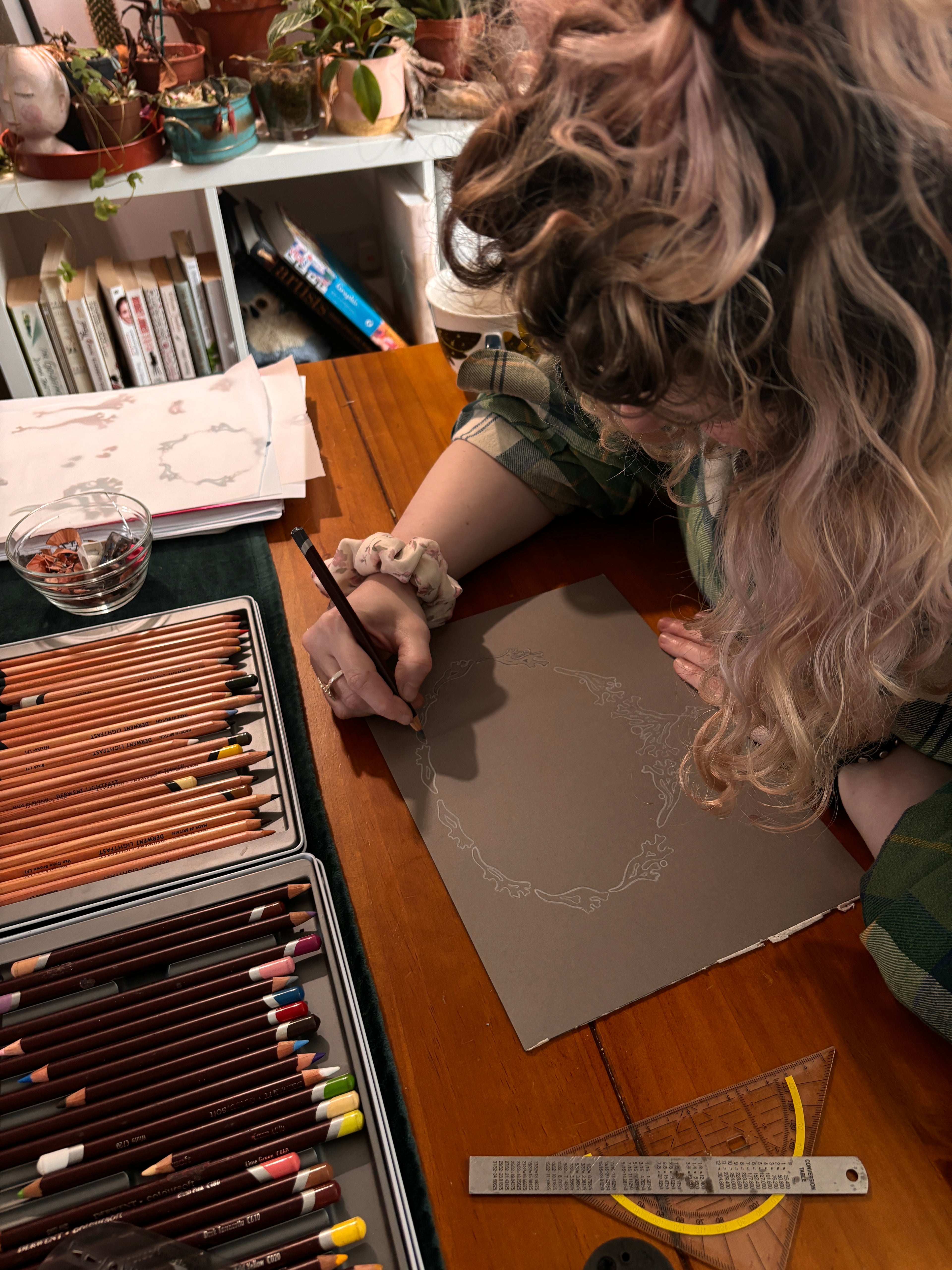 woman drawing a jewellery design on a grey piece of paper