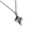 Silver star-shaped pendant on a chain against a white background