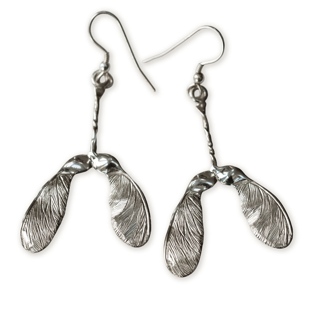 Silver sycamore seed earrings on a white background
