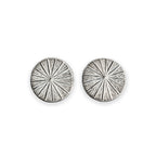 Pair of silver circular earrings with radiating design on a white background