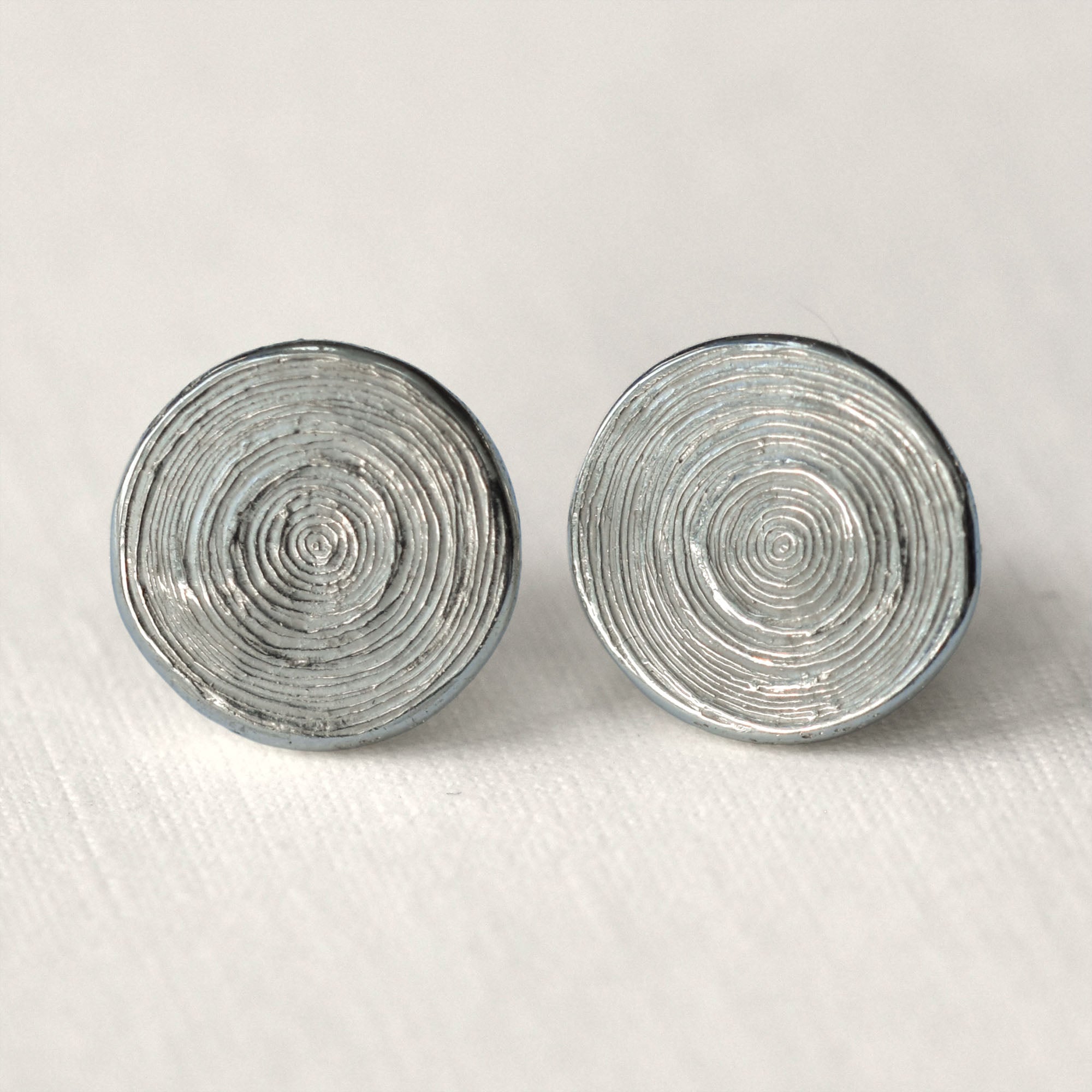 Pair of silver spiral earrings on a light gray background