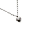 Silver heart-shaped pendant on a chain against a white background