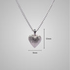 Silver heart pendant on silver chain with shiny engraved flowing lines. Added dimensions of 8mm x 12mm