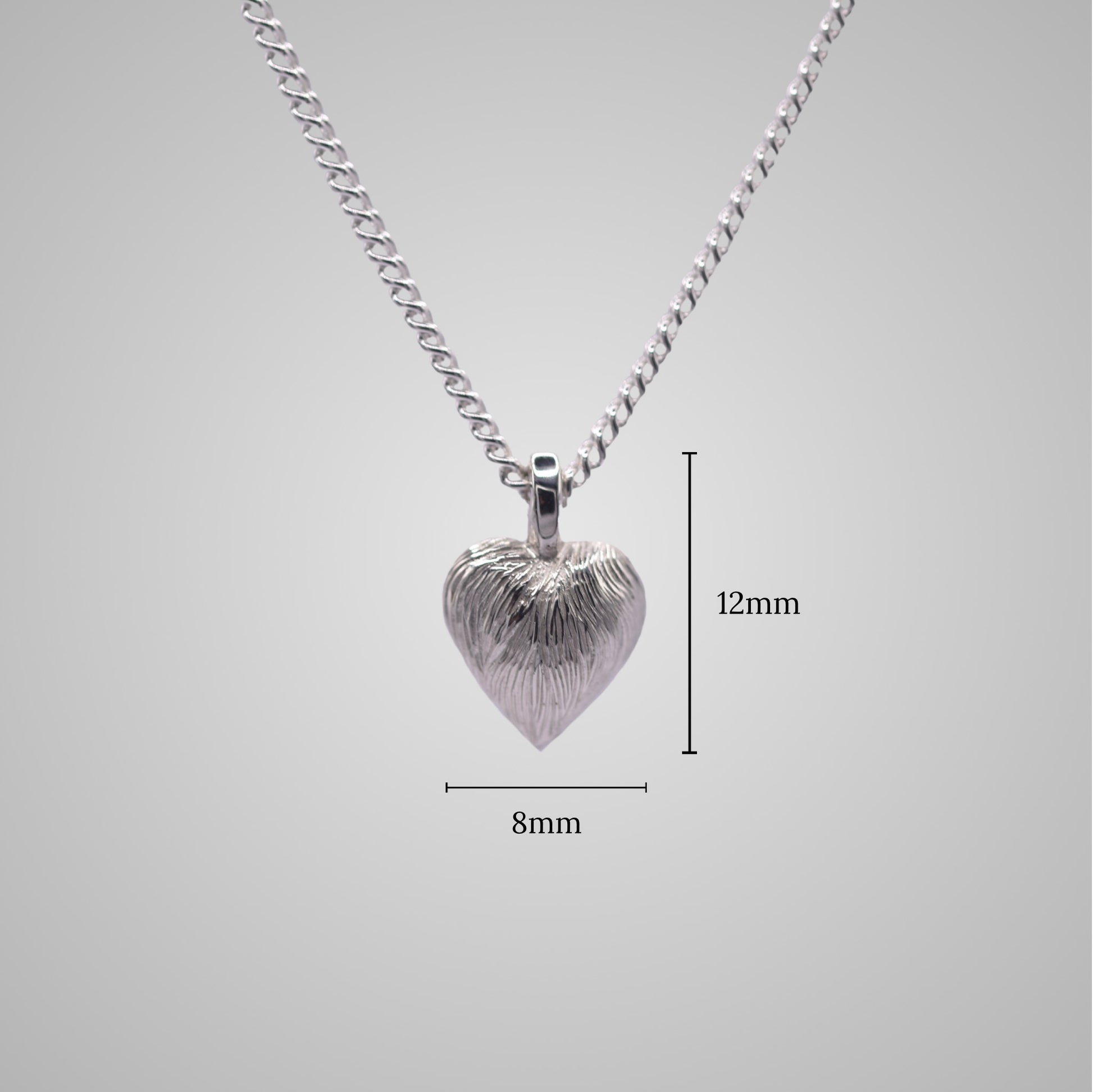 Silver heart pendant on silver chain with shiny engraved flowing lines. Added dimensions of 8mm x 12mm