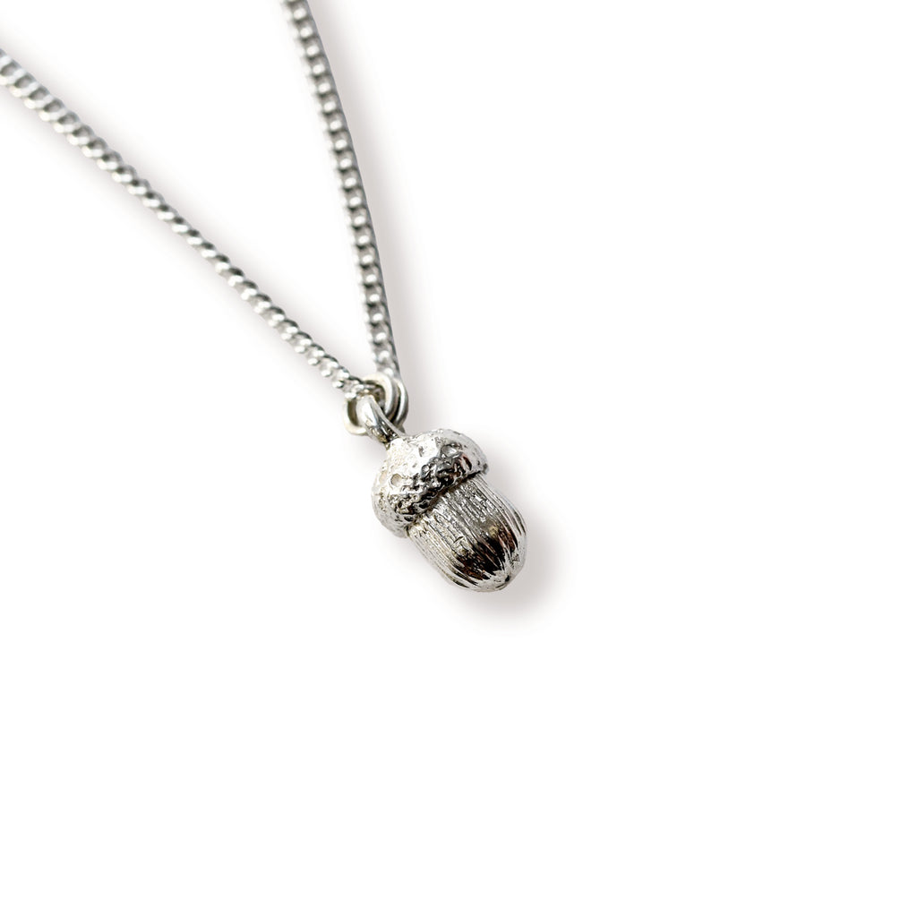 Silver acorn pendant on a chain against a white background