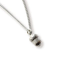 Silver acorn pendant on a chain against a white background