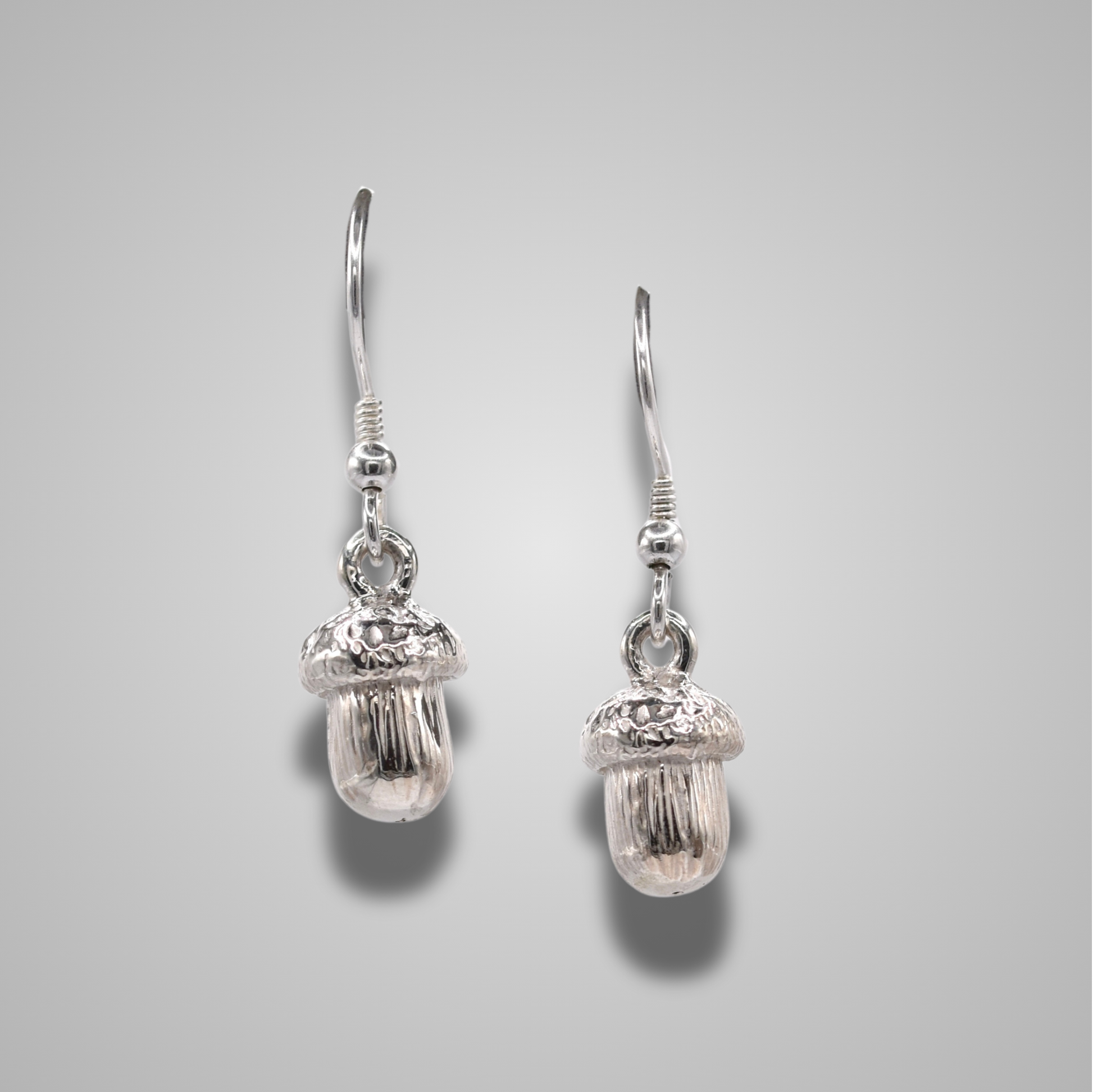 Sterling silver acorn drop earrings on hooks. Intricate details with a shiny polished finsh. 