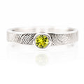 Silver ring with a green gemstone on a white background