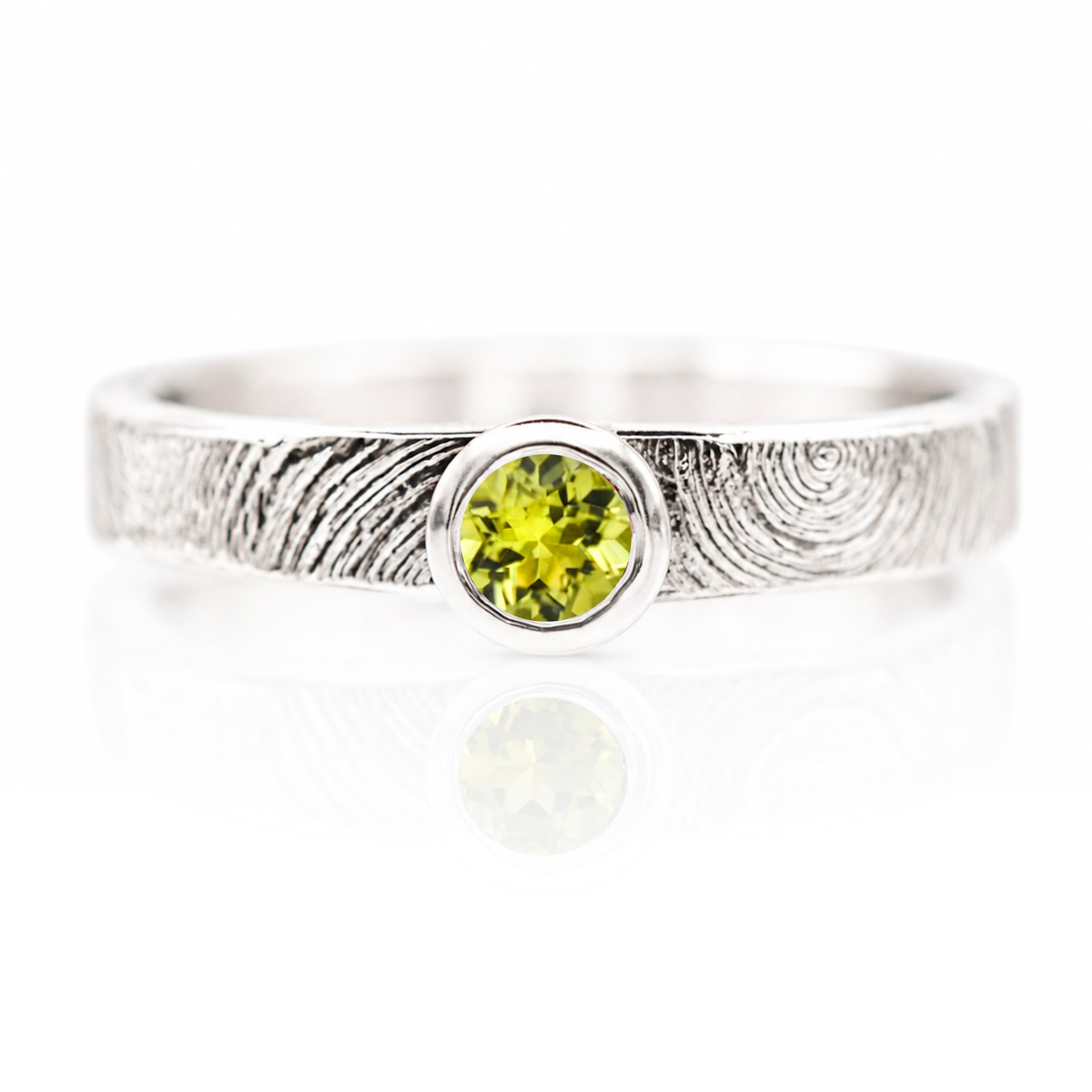 Silver ring with a green gemstone on a white background