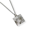 Silver necklace with a square pendant with engraved waves on a white background