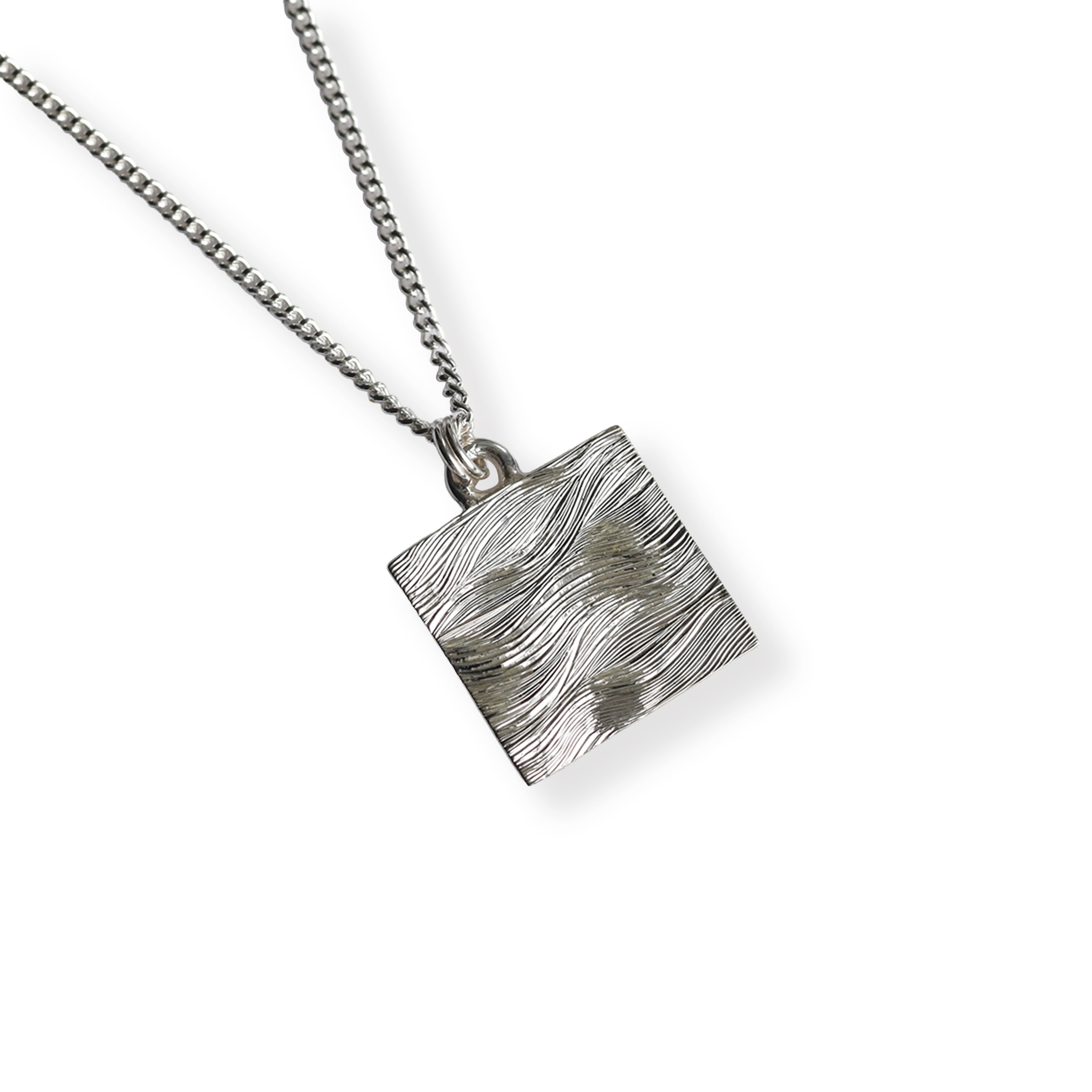 Silver necklace with a square pendant with engraved waves on a white background
