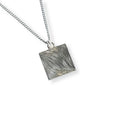 Silver flowing lines on a square pendant necklace on a white background