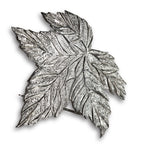Silver leaf-shaped brooch on a white background
