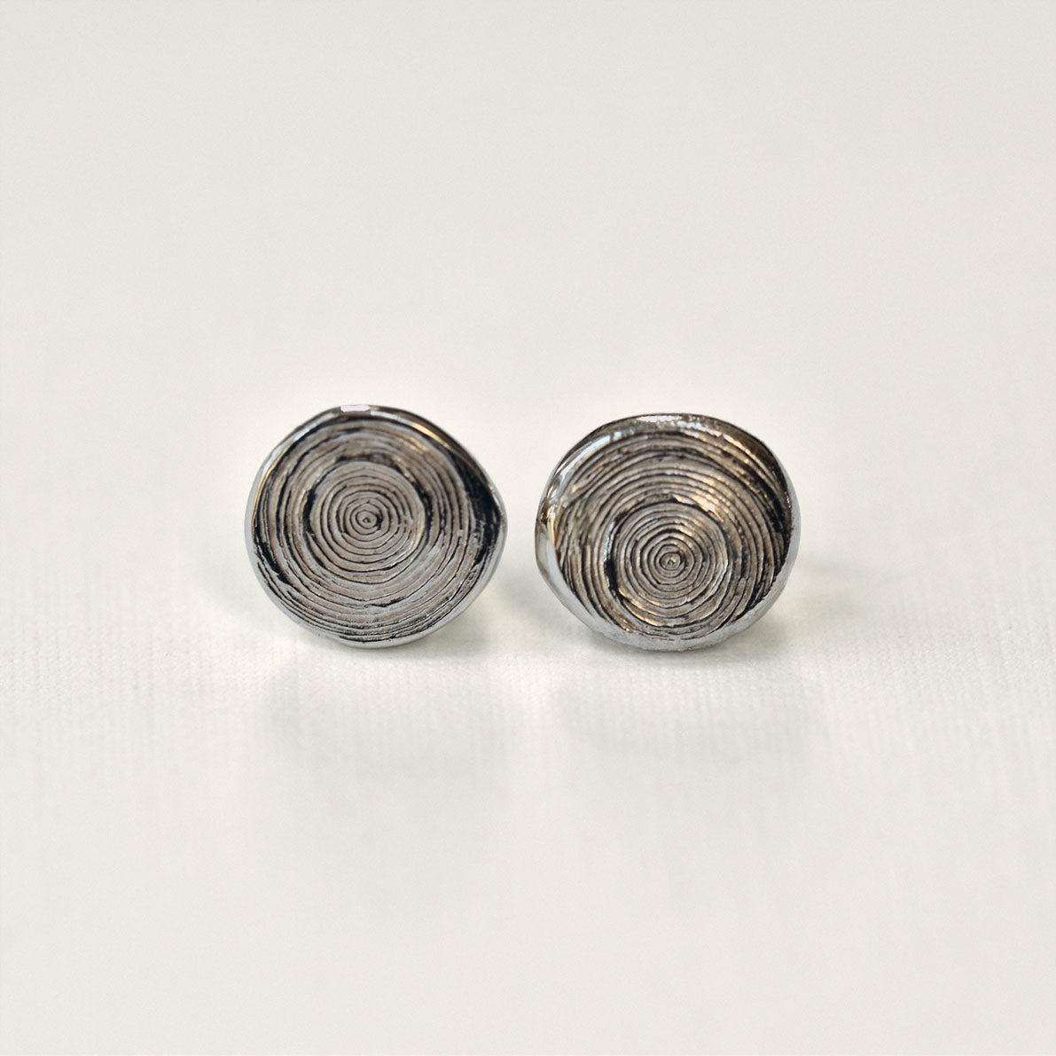 Pair of silver spiral earrings on a light gray background