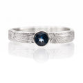 Silver ring with a blue gemstone on a white background