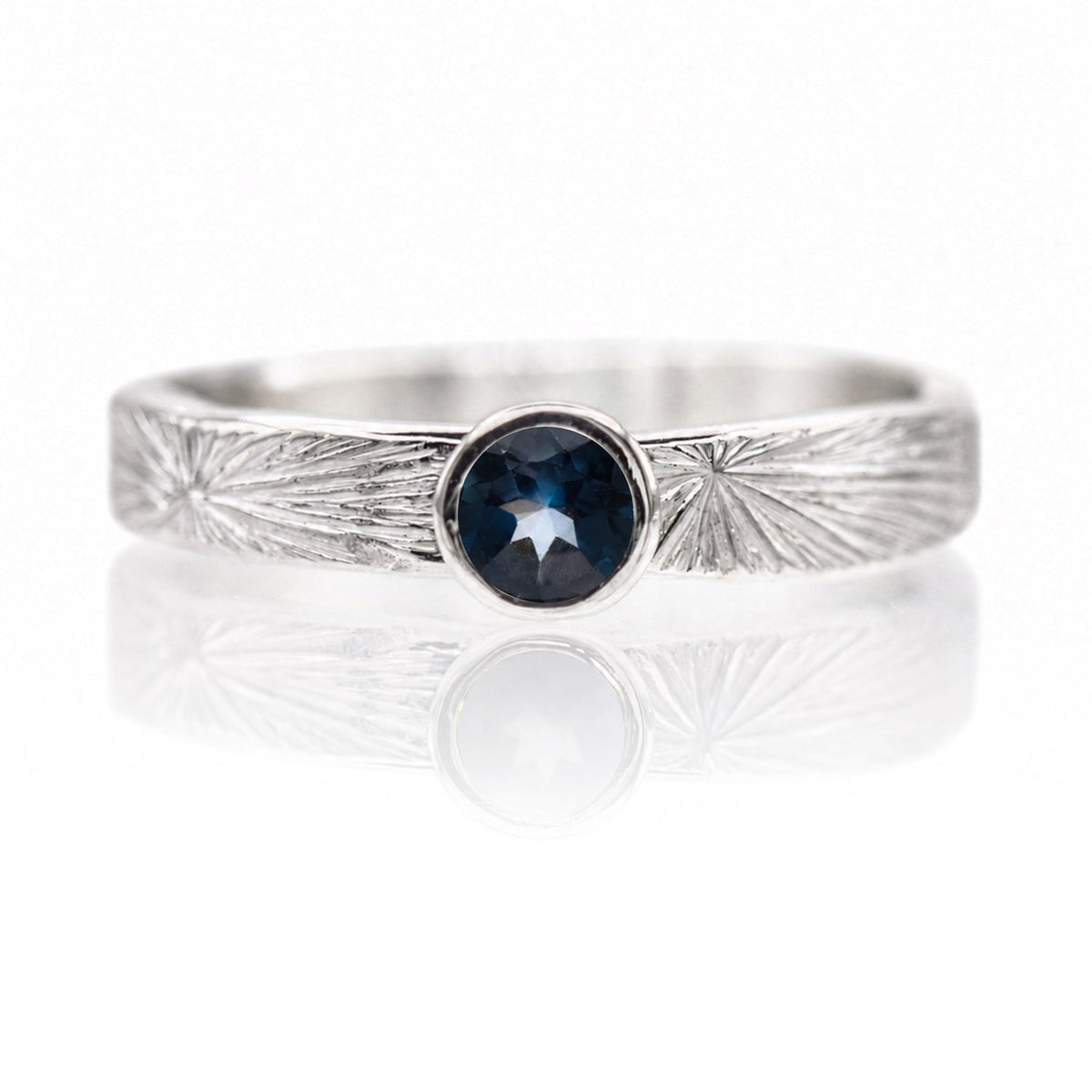 Silver ring with a blue gemstone on a white background