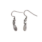 Pair of silver sycamore seed shaped earrings on a white background