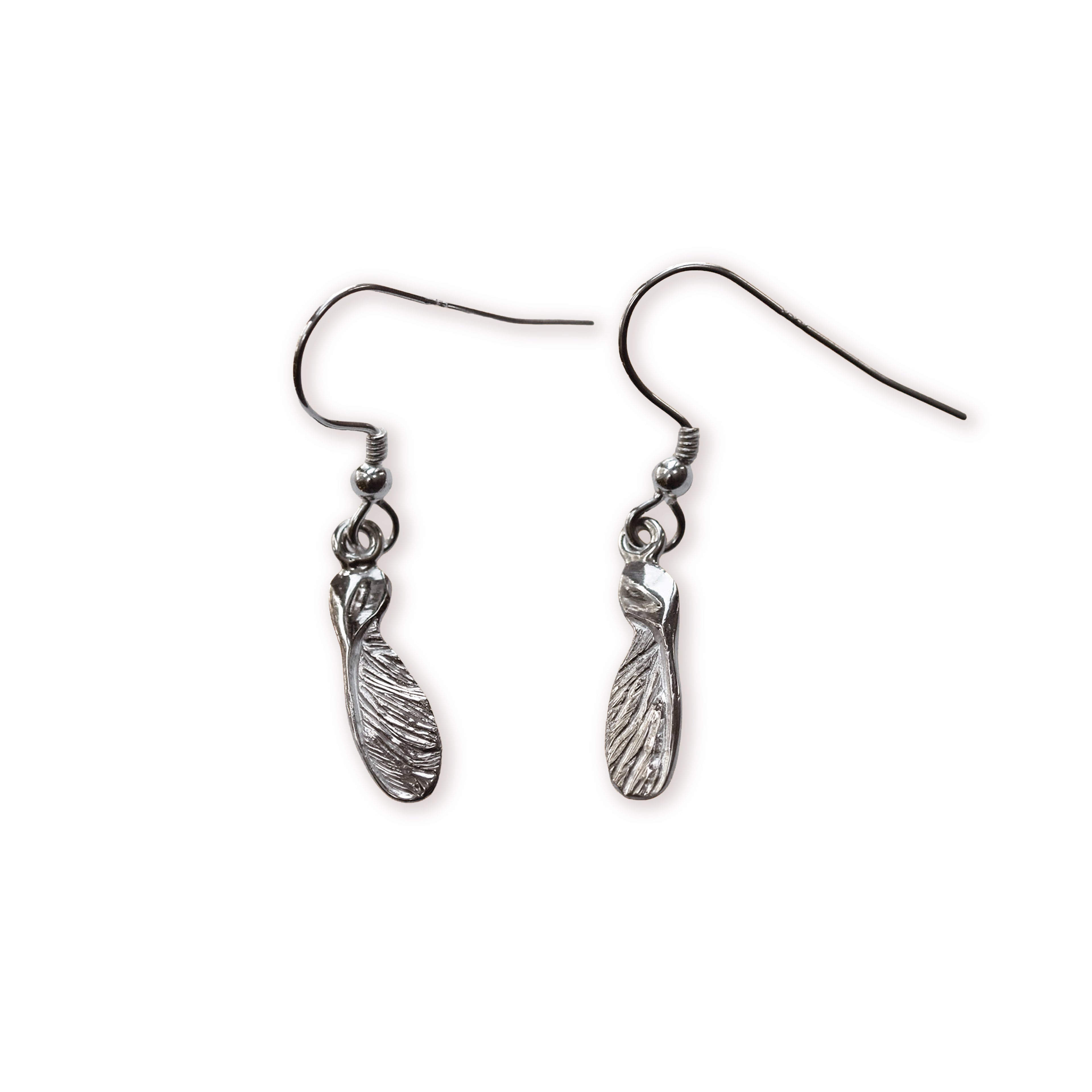 Pair of silver sycamore seed shaped earrings on a white background