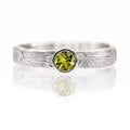 Silver ring with a green gemstone on a white background
