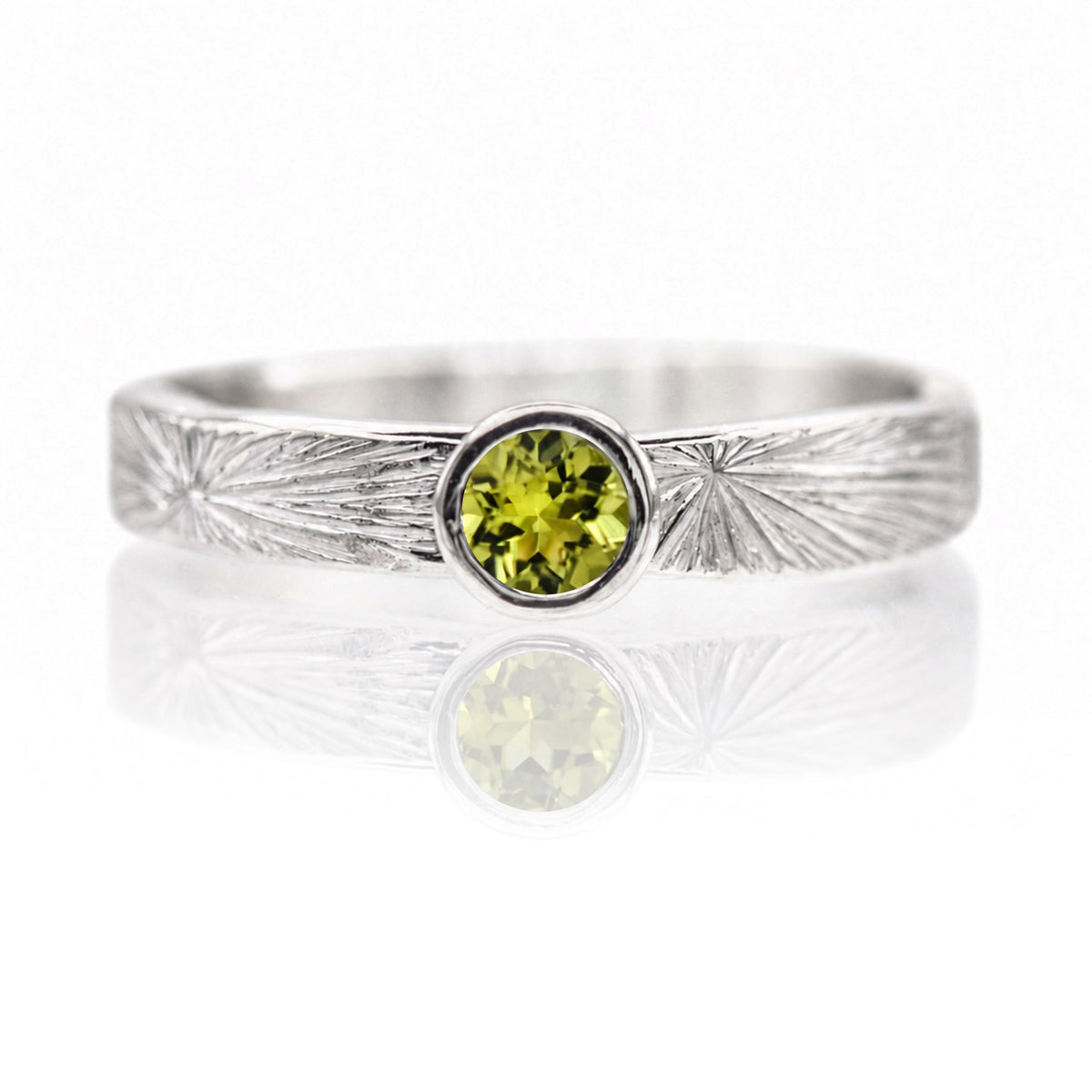 Silver ring with a green gemstone on a white background