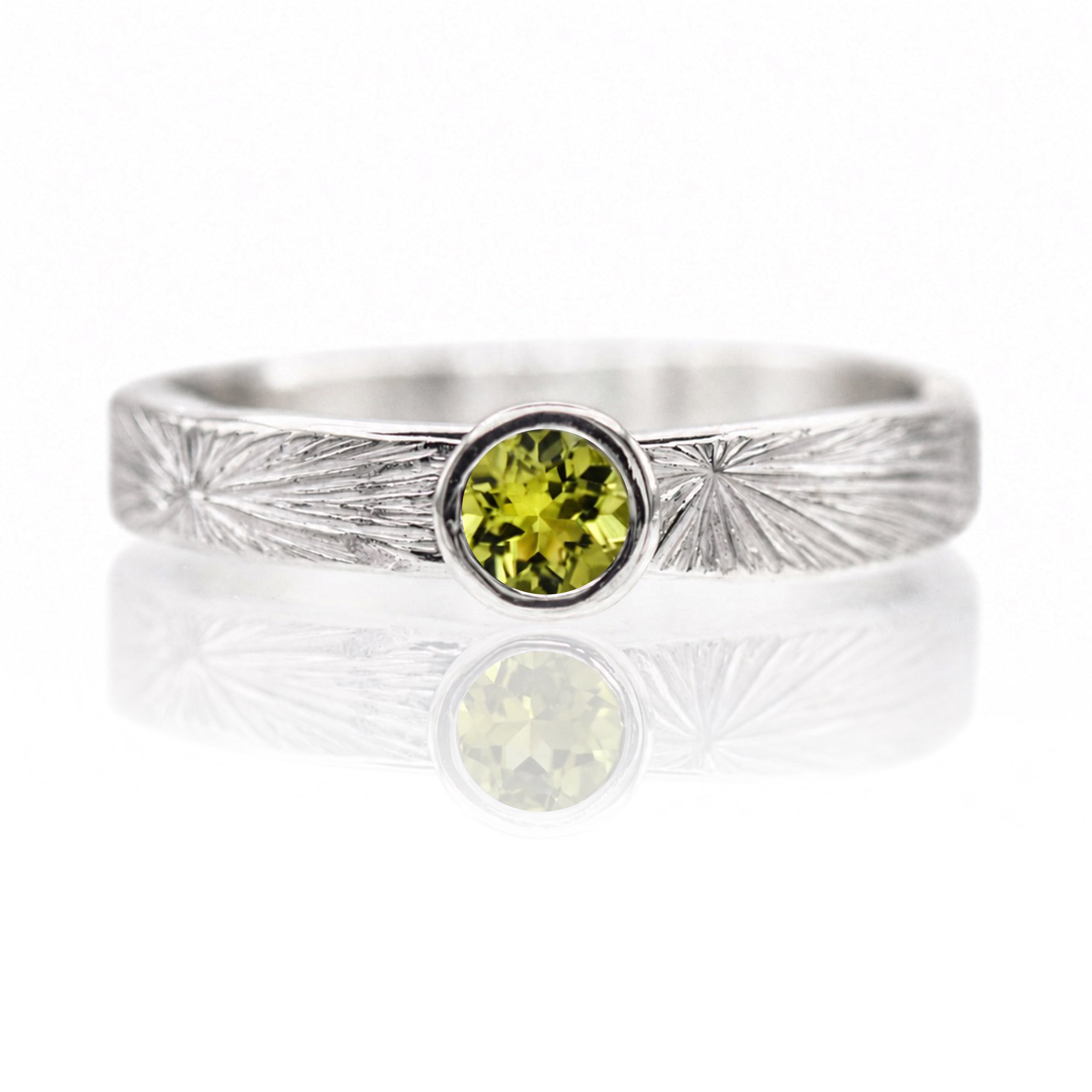Silver ring with a green gemstone on a white background
