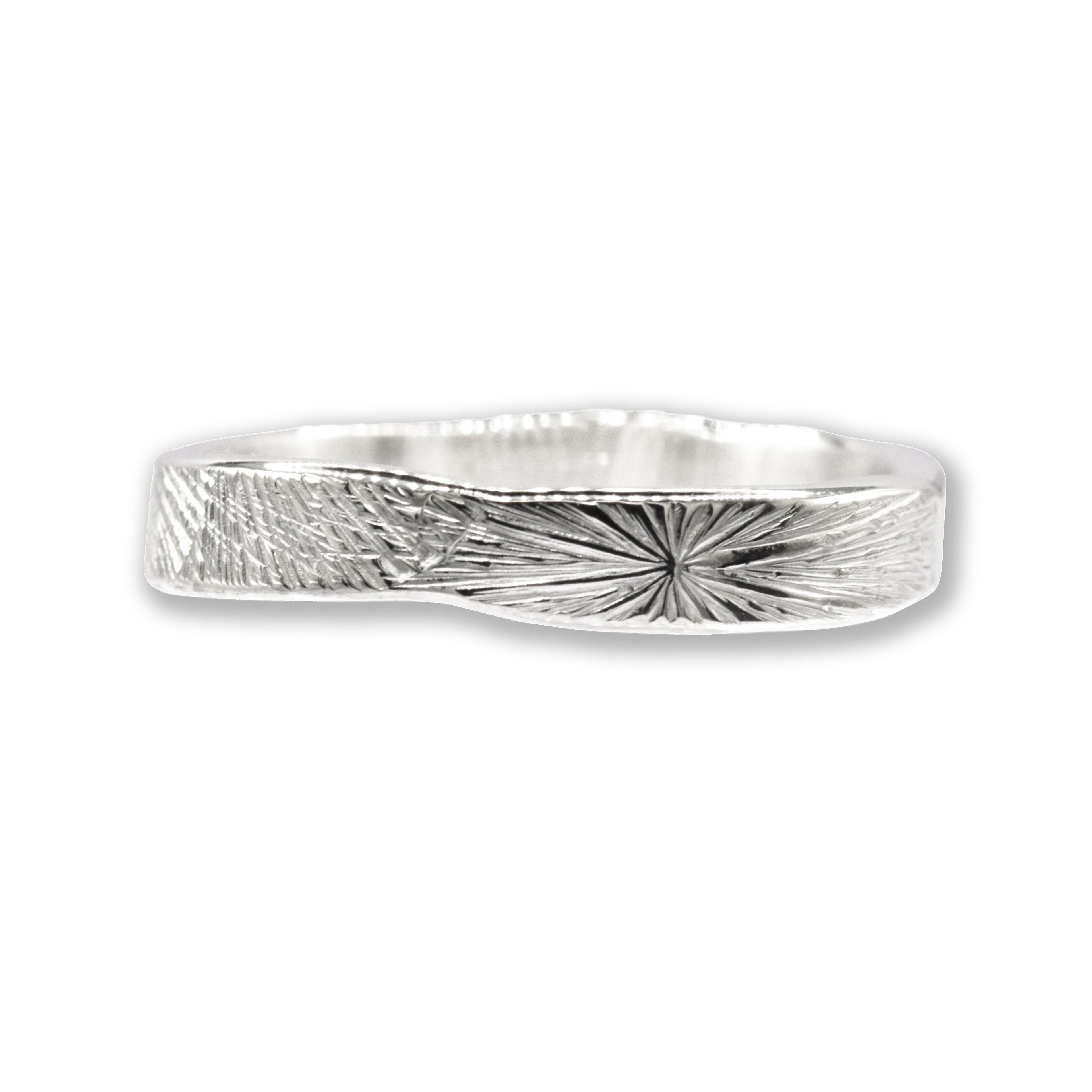 silver ring with radiating pattern on a wite background
